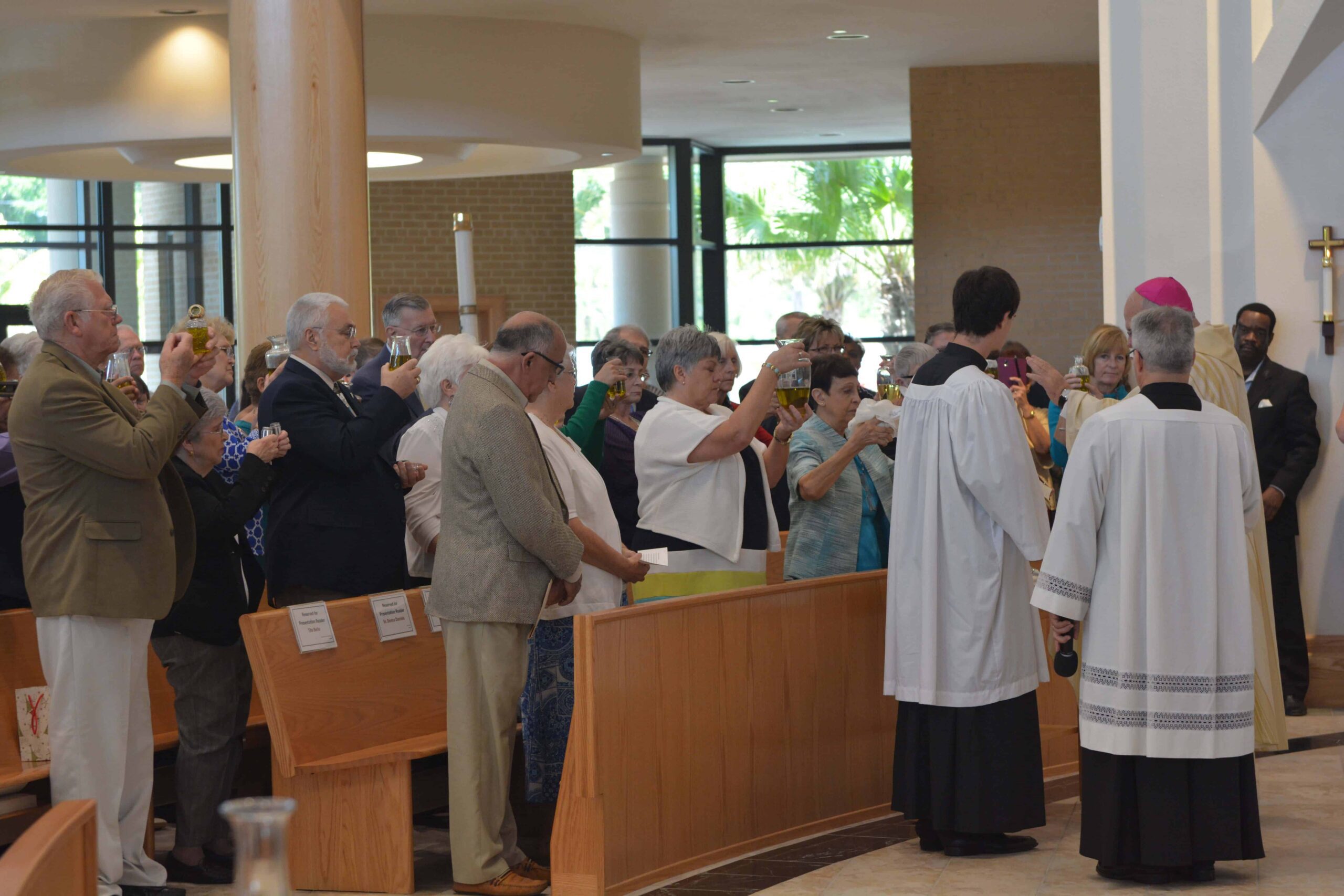 Parish representatives holding their parish’s Oil of the Sick as it is blessed. Photo credit: Maria Mertens.