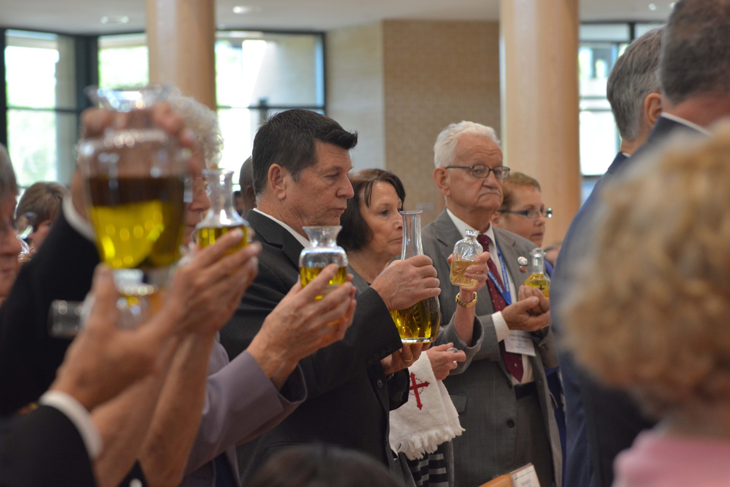 Parish representatives holding their parish’s Oil of Catechumens as it is blessed.  Photo credit: Maria Mertens.